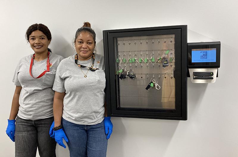 two staff members with a Traka Box, an automated key locker system